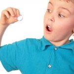 Child with a pill in his hand