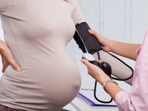 врач измеряет давление беременной