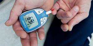 Женщина измеряет уровень сахара в крови глюкометром